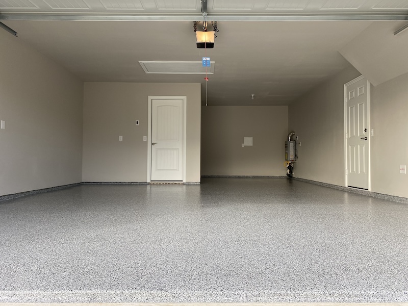 Epoxy garage floor with color flakes and 2-white doors in Fort Worth.